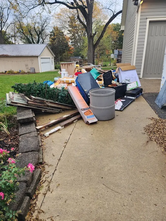 Dumpster being loaded with debris for 12 Yard Dumpster Rental in Lansing